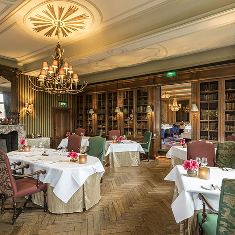 Een eetzaal bij Chateau St. Gerlach met groene en roze eetstoelen
