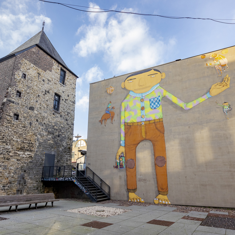 Street art in Heerlen van een mannetje, naast een kerk. 