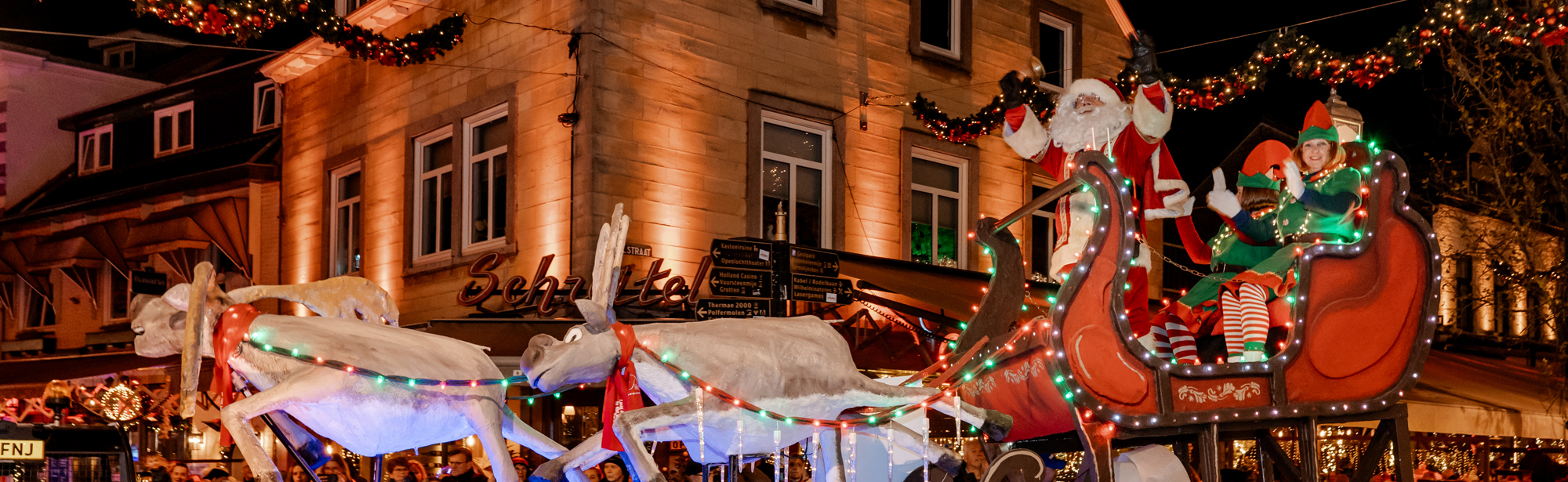 Paradewagen met kerstslee en rendieren met kerstman en elfjes verkleed