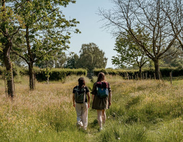 Twee meiden wandelen door de groene natuur op een zomerse dag